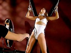 Blonde submissive model gets bound to a wall while a guy punishes her with a whip