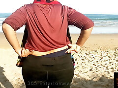 жена демонстрирует свое декольте на открытом пляже
