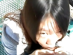 mujer asiática sopla chicos en el parque en plena luz del día
