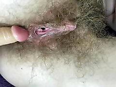 Fur Covered nymph fucks her wet big clit pussy with dildo in close up
