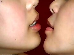 2 Japanese gals are doing some weird kissing with a mouth speculum