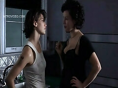 Jennifer Tilly pulling down her bra to display lots of