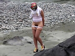 girlfriend in nylon stockings and heels posing by the river. a photo