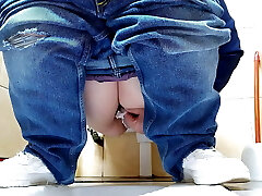 Hot MILF in jeans peeing in a public restroom