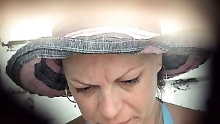 Mature white lady in blue bikini urinates in the public toilet room on the beach