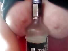 Bottle between tits