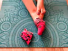 Gloria Gimson in pink socks caresses her katun saxe com on a yoga mat