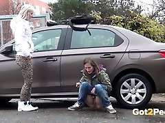 Two shameless teen bitches piss a lot near luxury car of their neighbor