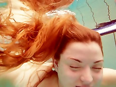 Sizzling redhead model Marketa swimming girl with boys many in a pool