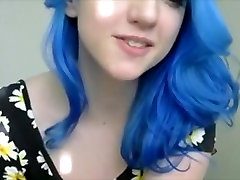 Fille aux cheveux bleus dans les fleurs joue avec de gros seins