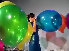 Sexy Girl Im Latex Kleid Weht um Einige Pop-Big Balloons