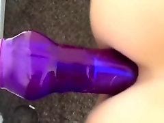 Fucking herself with a purple fake jock