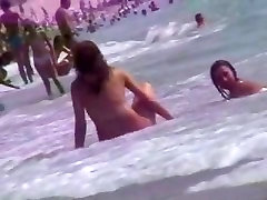 Smoking hot brunettes are relaxing on the sucking fake boobs beach