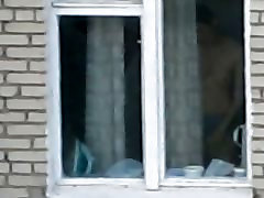 गर्म सुनहरे बालों वाली लड़की दृश्यरतिक खिड़की से झांकना