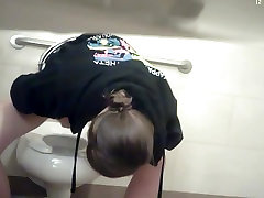 Girl pissing and stretching legs not to touch dirty bowl
