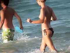 Топлес девушки играют на пляже и получать voyeured