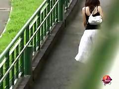 Азиатские девушка в длинной белой юбке получает улицу превратили в акулу