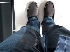 Long pisse dans des jeans, des chaussettes noires et des chaussons mocassins