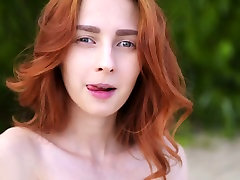 Red haired beauty Helga Grey plays with her big boobies on the beach