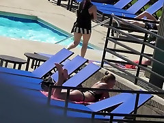 Sexy babe relaxes by the pool