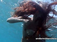 Julia is swimming underwater nude in the sea