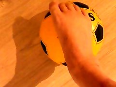 ноги на желтый футбольный мяч
