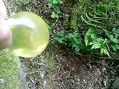 inflating condom with piss in the woods