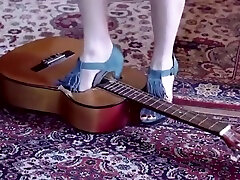 Girl crushing a guitar in stealing small hairy heels