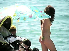 裸体的女孩拿起偷窥凸轮在海滩上的裸体