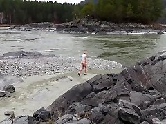 girlfriend in nylon pantyhose and heels posing by the river. a photo