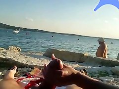 On a nude beach the wife stokes my cock while a voyuer watches