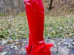 señora l sexy caminando con botas rojas extremas en el bosque