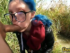 cutie avec un plug anal et des lunettes de veste aux cheveux bleus aime avoir des relations sexuelles en suçant une bite sur la rivière