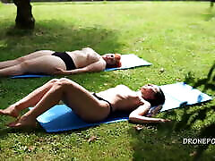 Two twisty lesbian hot sex girls sunbathing in the city park