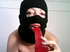 Masked teen giving a blowjob to a dildo