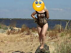 Pretty woman in a dick bulge flashing bodysuit on the beach