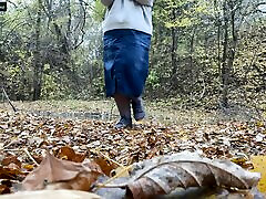 milf con curvas en una falda larga orinando en el parque de otoño