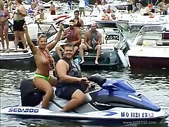 Party girls take off their bikini tops on boats at the lake