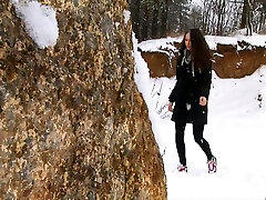 Brunette eva galan young chick walks in the winter forest and pisses behind the rock