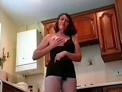 Filthy granny with saggy tits is posing in pantyhose in the kitchen
