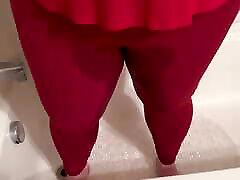 火辣的女孩绝望的尿尿在紧红色瑜伽的裤子