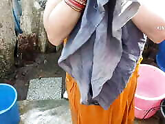 Indian house wife bathing outside