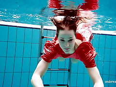Cute babe in crimson sexy open dress swimming