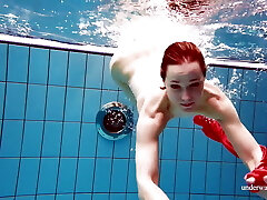 Ultra-cute babe in red sexy open dress swimming