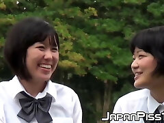 Cute Japanse schoolgirl with ponytails pisses in the wind