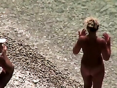 Handjob on candid beach with older nudist couple