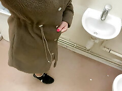 Stylish pisses in the sink in the disabled public toilet