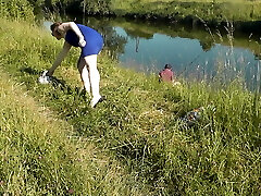 plage sauvage. milf sexy platine bronzant nue au bord de la rivière, un pêcheur au hasard regarde. nue en public. plage de nudistes
