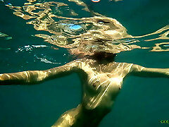 Naked model swims on a public beach in Russia.