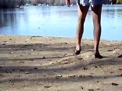 Crossdresser at the lake in hose and high-heeled shoes